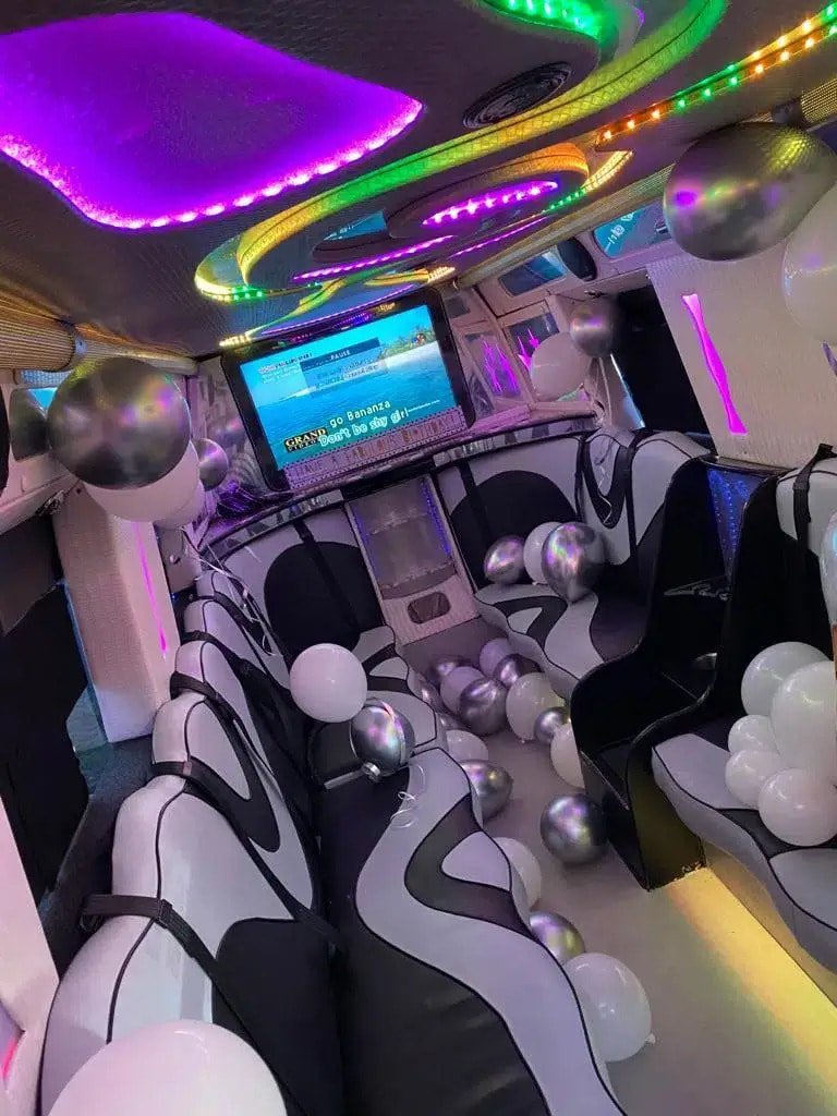 Wave-pattern leather seating and TV screens inside a party van